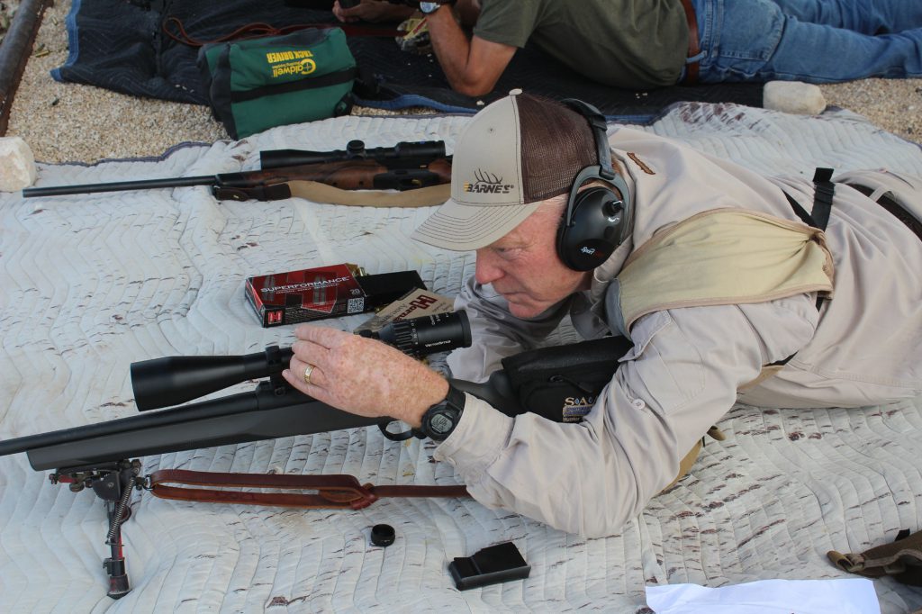 Dialing the range is far more precise than holding a crosshair somewhere above a distant target—but it takes a lot of range work to verify the data. On the SAAM range in Texas, Boddington is working the turret on a Vector scope on a Sabbati Sapphire in.300 Winchester Magnum.